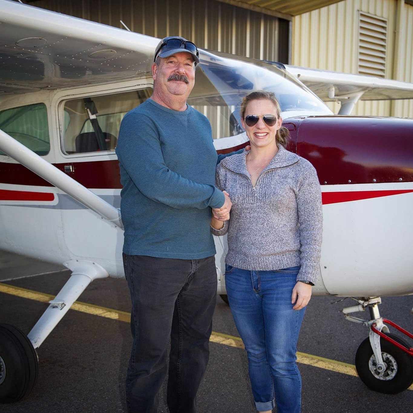 Chip Bornstein congratulating a new pilot beside a Cessna